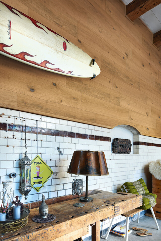 Echt natürlich, echt kernig: Holzpaneele aus Eiche Natürliche Holzpaneele halbhoch an einer Wand mit aufgehängtem Surfbrett