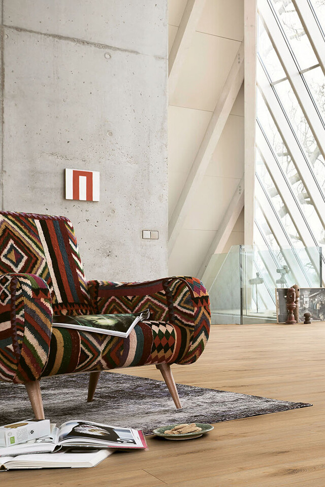 Ein bunt gemusterter Sessel und Boden in Holzoptik passen gut zum afrikanischen Wohnstil Laminat MeisterDesign. laminate LL 250 Eiche Dakar 6385