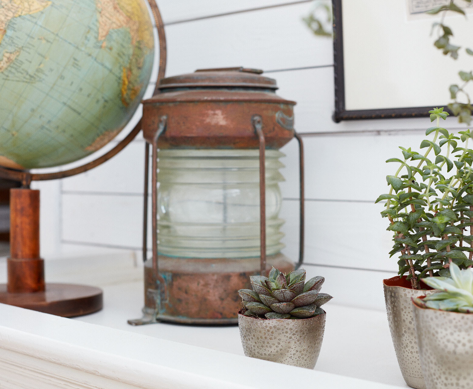 Maritime Deko muss nicht kitschig sein. Die rostige alte Laterne und der Globus erinnern an die großen Zeiten der Seefahrer Alte, rostige Laterne, Globus und grüne Pflanzen als Dekoteile