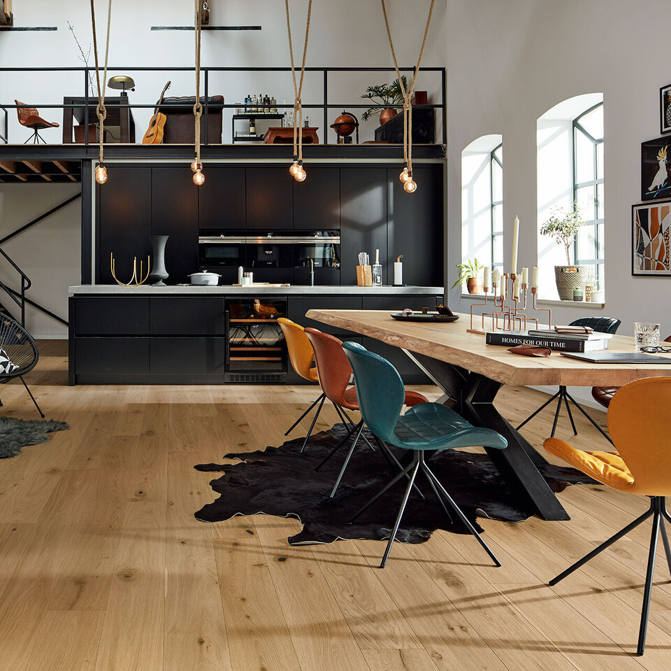 Parkett eignet sich für fast alle Räume, auch für die Küche Wasserresistente und ultramattlackierte Parkett Landhausdielen in einer offenen, schwarzen Küche